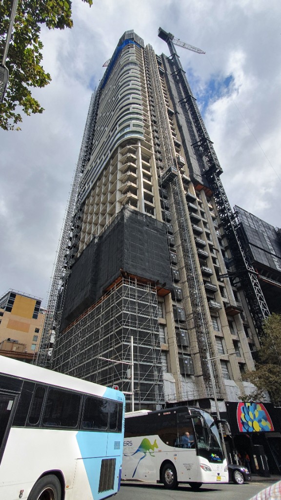 Commercial tower under construction viewed from street level.